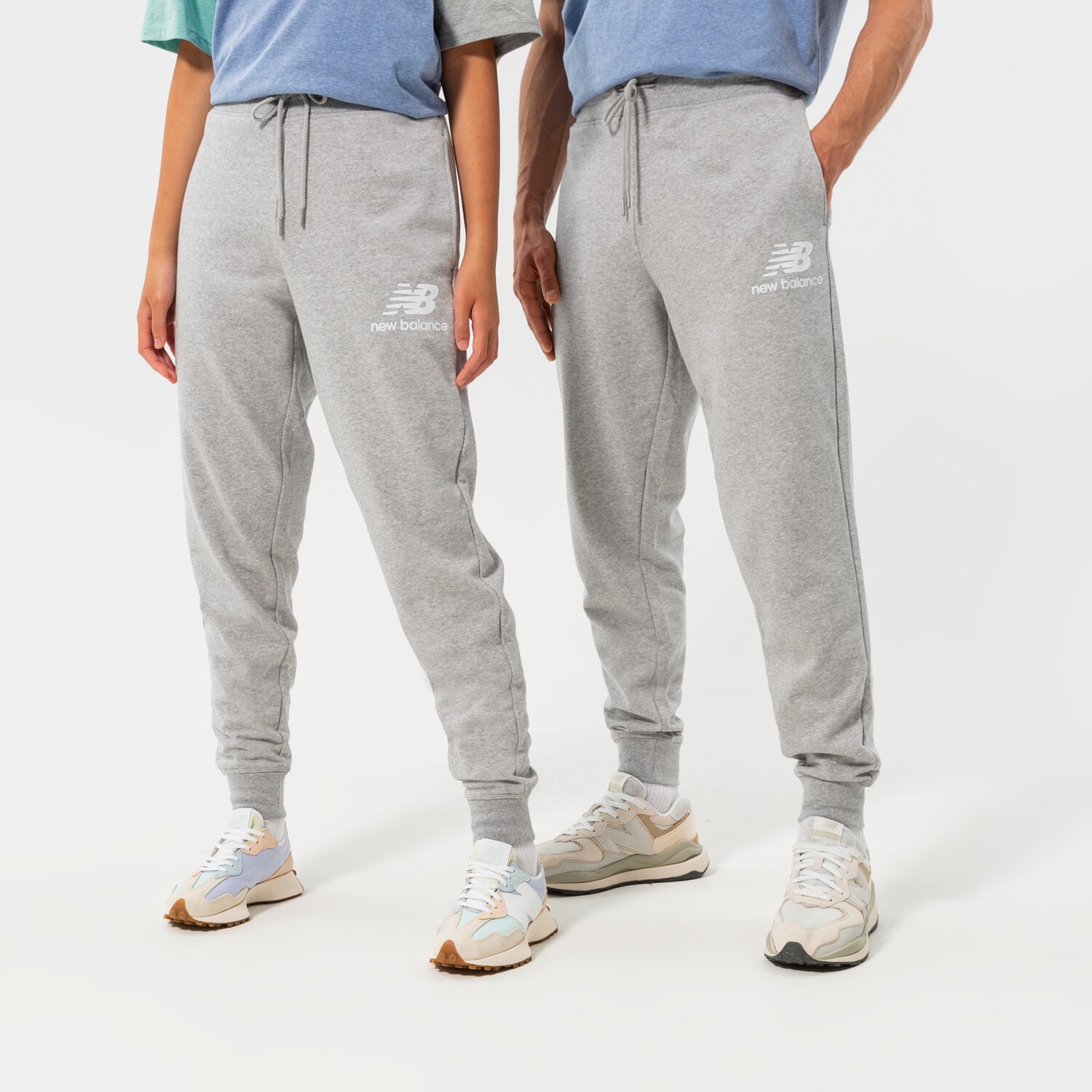 Spodnie sportowe męskie NEW BALANCE SPODNIE NB ESSENTIALS STACKED LOGO SWEATPANT MP03558AG SZARY