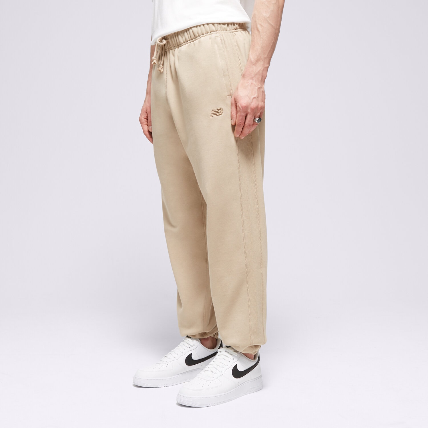 Spodnie sportowe męskie NEW BALANCE SPODNIE ATHLETICS FRENCH TERRY JOGGER MP41508SOT BEŻOWY