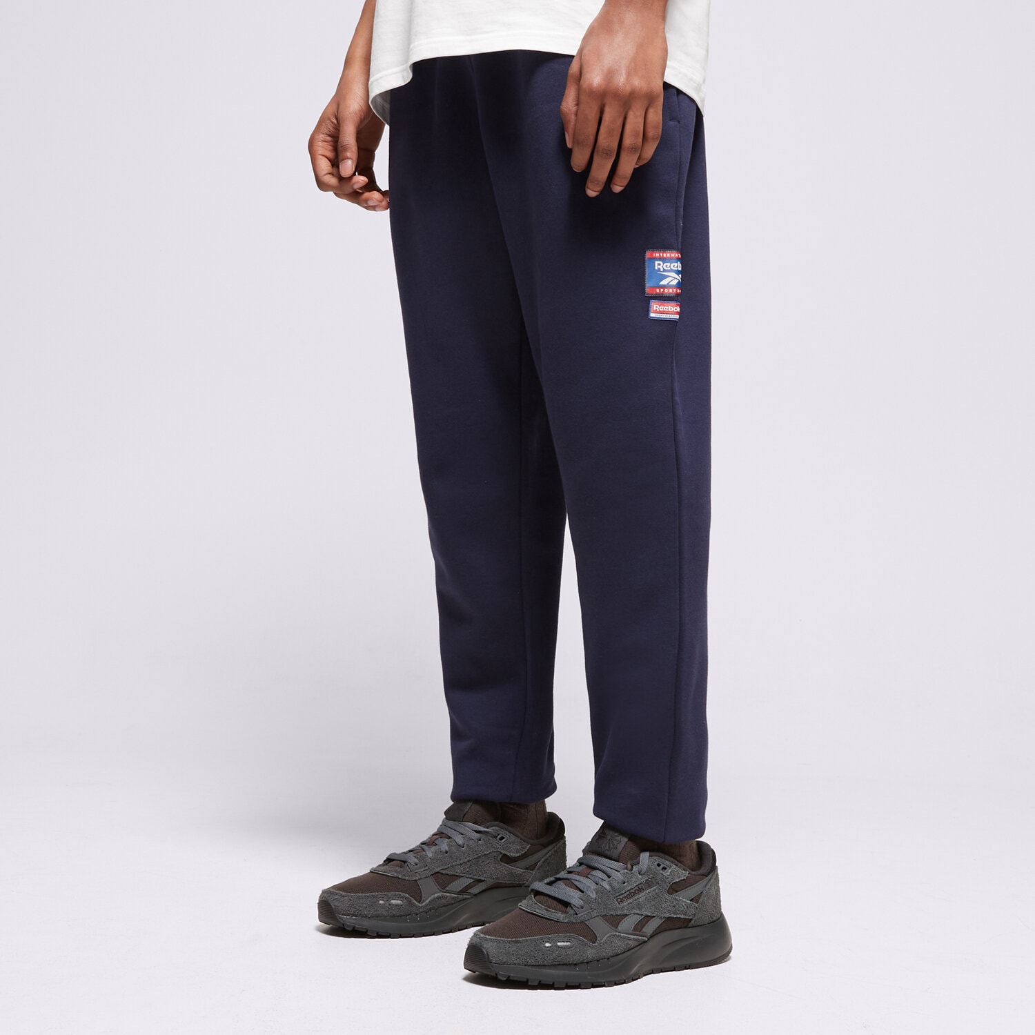 Spodnie sportowe męskie REEBOK SPODNIE RI BADGE 100205446 GRANATOWY
