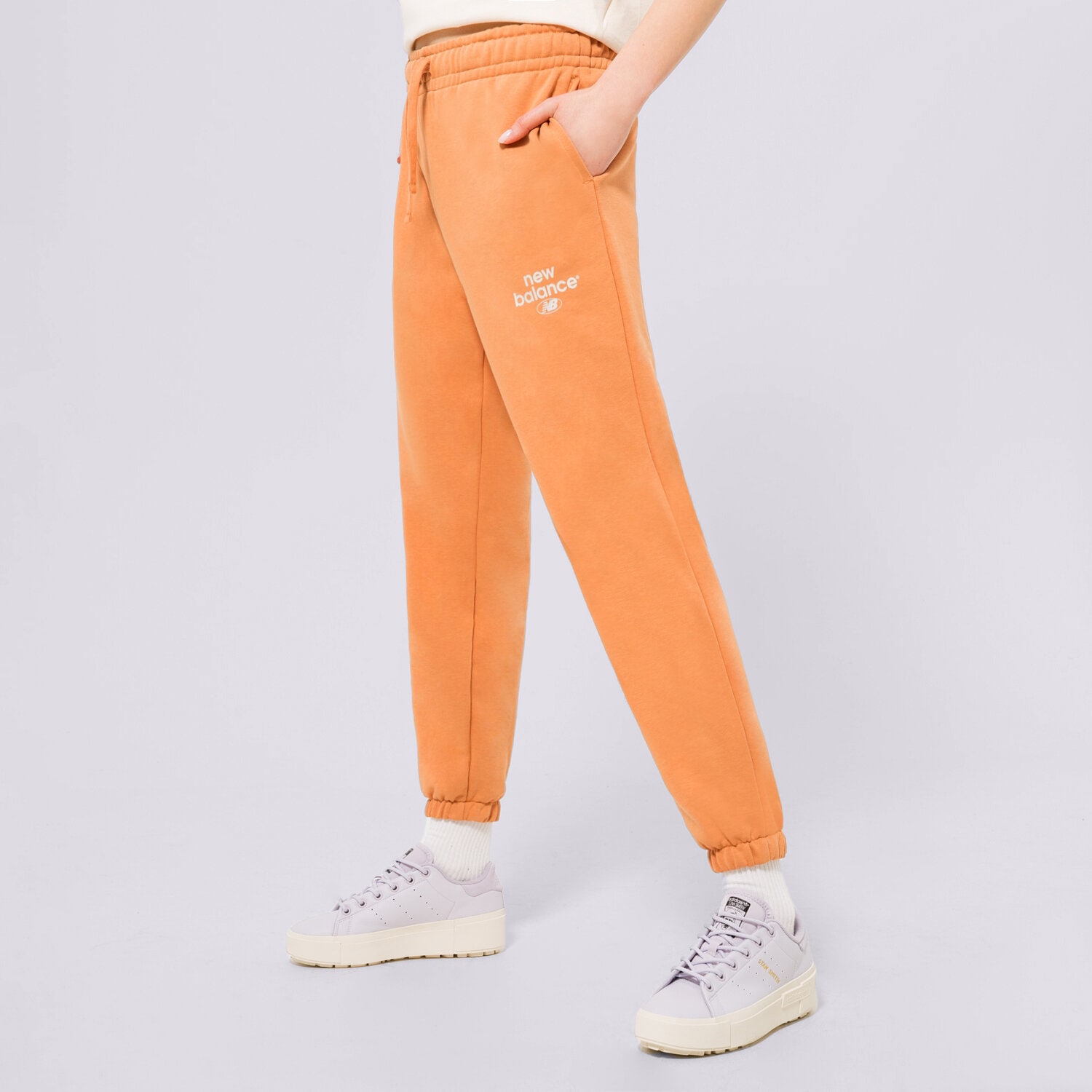 Spodnie sportowe damskie NEW BALANCE SPODNIE NB ESSENTIALS GRAPHIC FLEECE WP31508SEI POMARAŃCZOWY